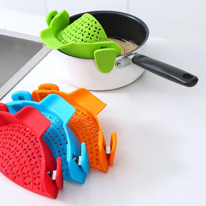 Silicone pot side drain stopper in black on a stainless steel pot edge, 11.3x22.5x5.9cm kitchen gadget