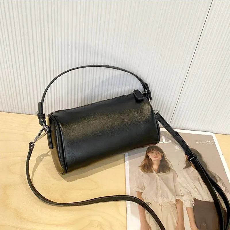 A soft genuine leather cylindrical crossbody bag for mobile phones in street style.