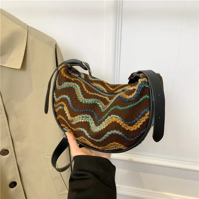 Women's straw woven crossbody bag showing woven texture and internal phone and document compartments