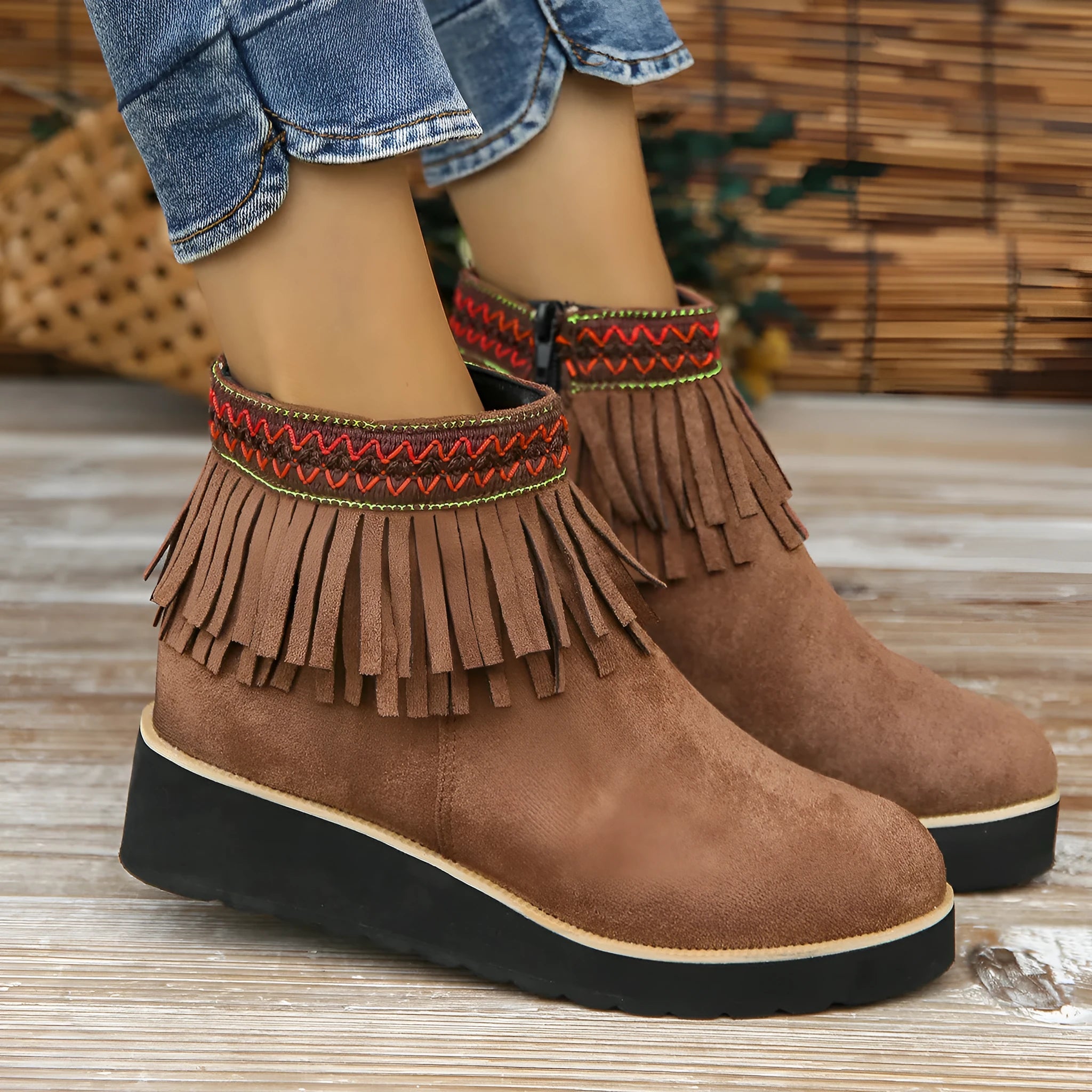 Women's dark brown suede ankle boot with wedge heel, side zipper, and decorative tassel.