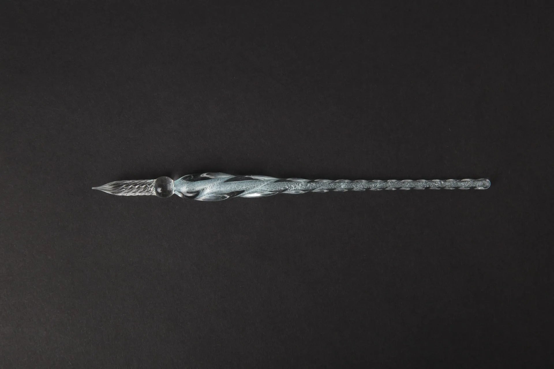 Hand-blown glass crystal pen with coloured ink in a transparent barrel on a gift box.