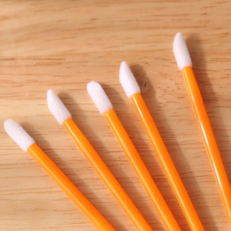 Pack of disposable lip brush wands with flocked brush tips and coloured handles.