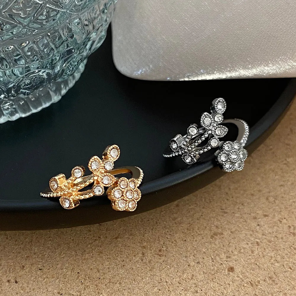 Gold and white women's open ring with floral leaf design and diamond treatment.