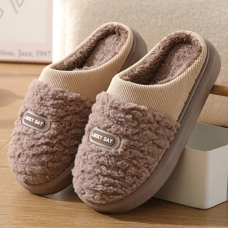 Men's grey plaid rabbit hair slippers with a thick sole, shown on a wooden floor.