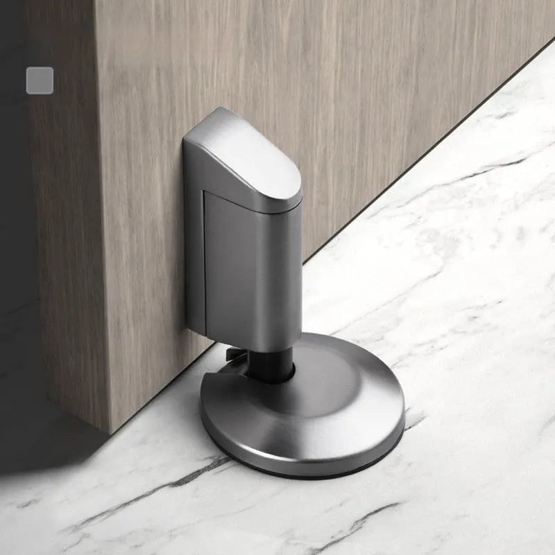 Zinc alloy invisible door stopper in brushed nickel finish on a wooden floor