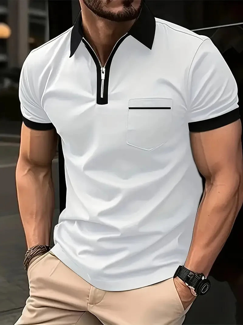 Man wearing a grey and navy blue casual t-shirt with a chest pocket and silver zip decoration detail.