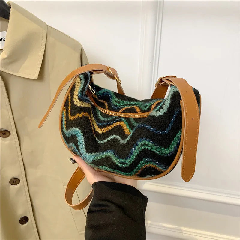 Women's straw woven crossbody bag showing woven texture and internal phone and document compartments