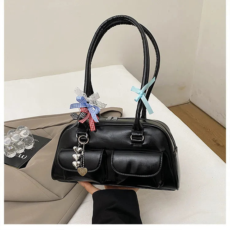 Retro one-shoulder pillow handbag in PU leather, shown in black with a flap closure and double straps.