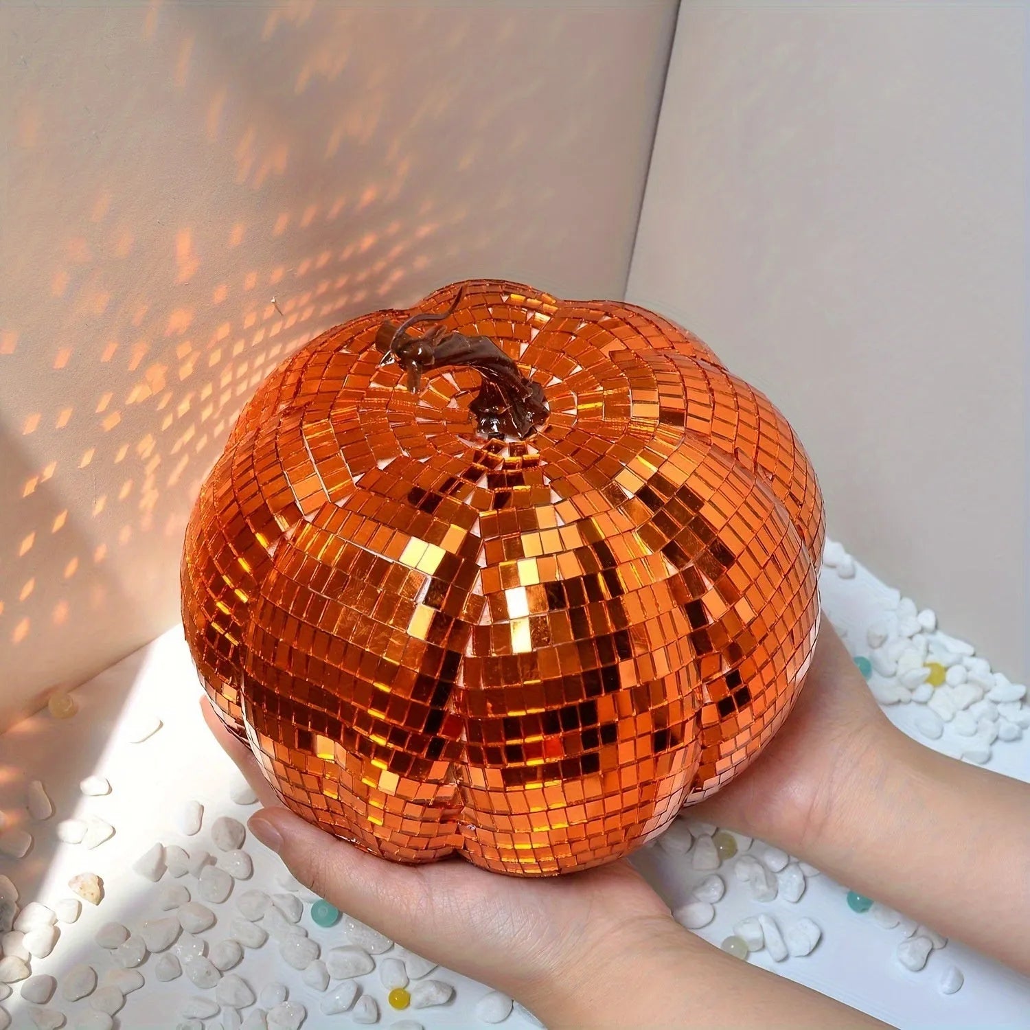 Chinese-style mirror glass pumpkin Halloween decoration in various sizes on a shelf.