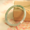Green waxy jade geometric bracelet with Chinese-style design showing handmade construction