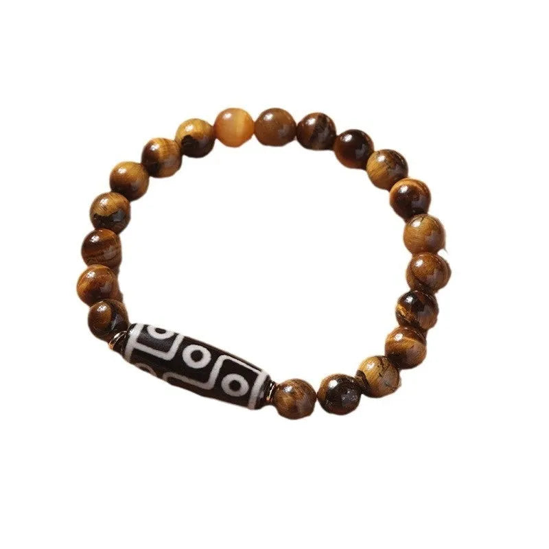 Single circle tigereye stone Buddhist prayer beads bracelet on wrist, showing ethnic design.