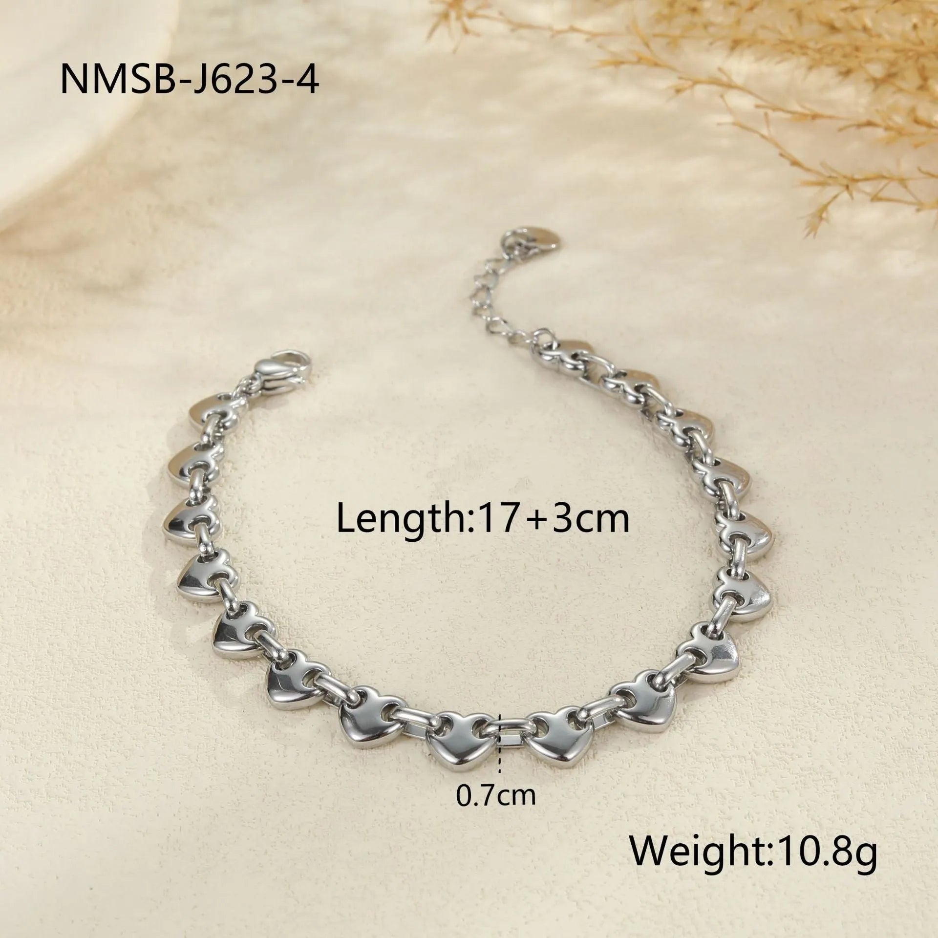 Hollowed-out heart geometry bracelet in stainless steel with gold electroplated finish on a wrist.