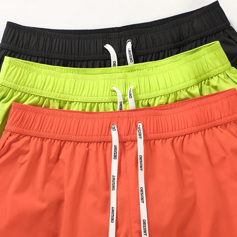 Men's loose-fit polyester surfing trousers in black, fluorescent green, and orange red colours