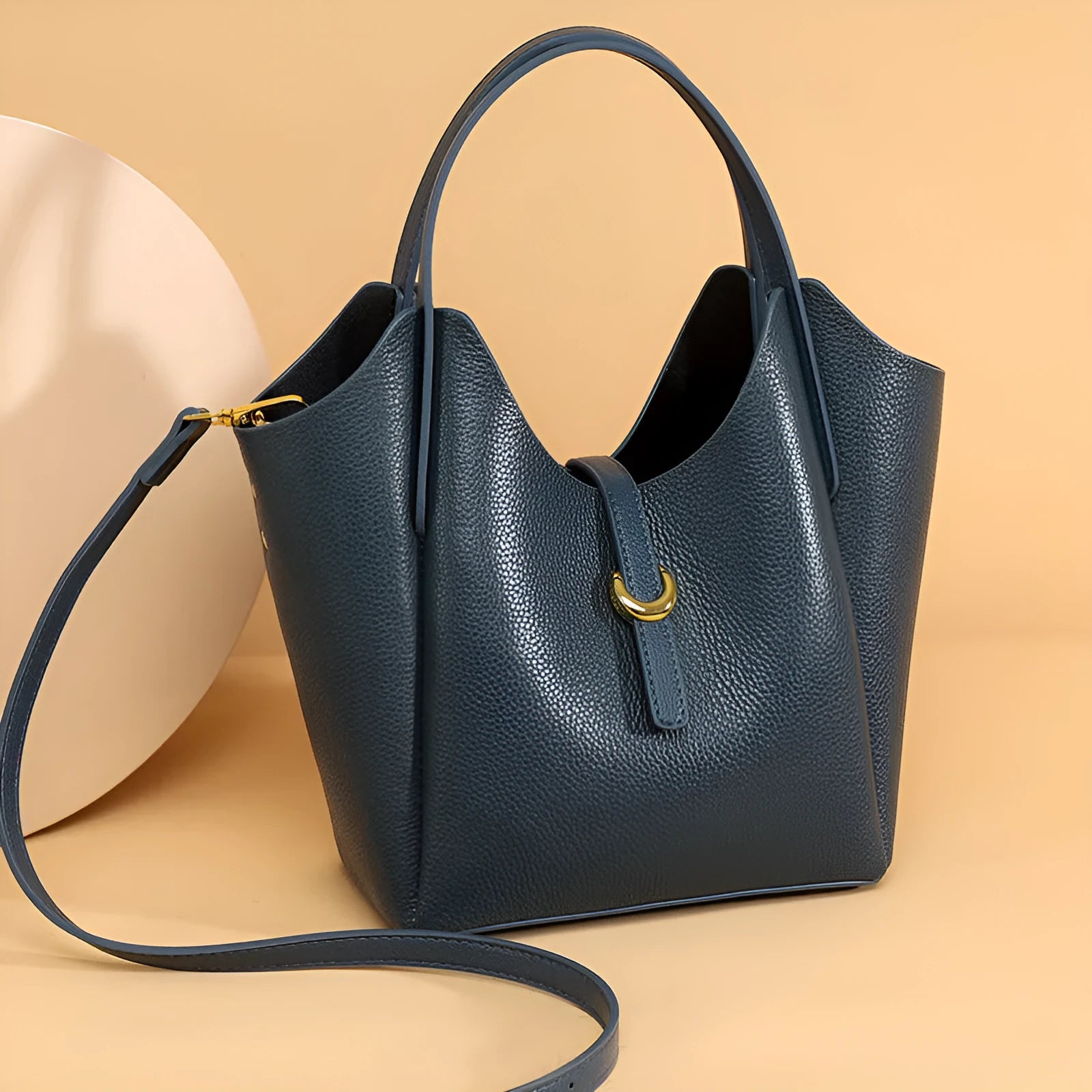 Genuine leather women's retro bucket handbag in beige with top handles and visible stitching.