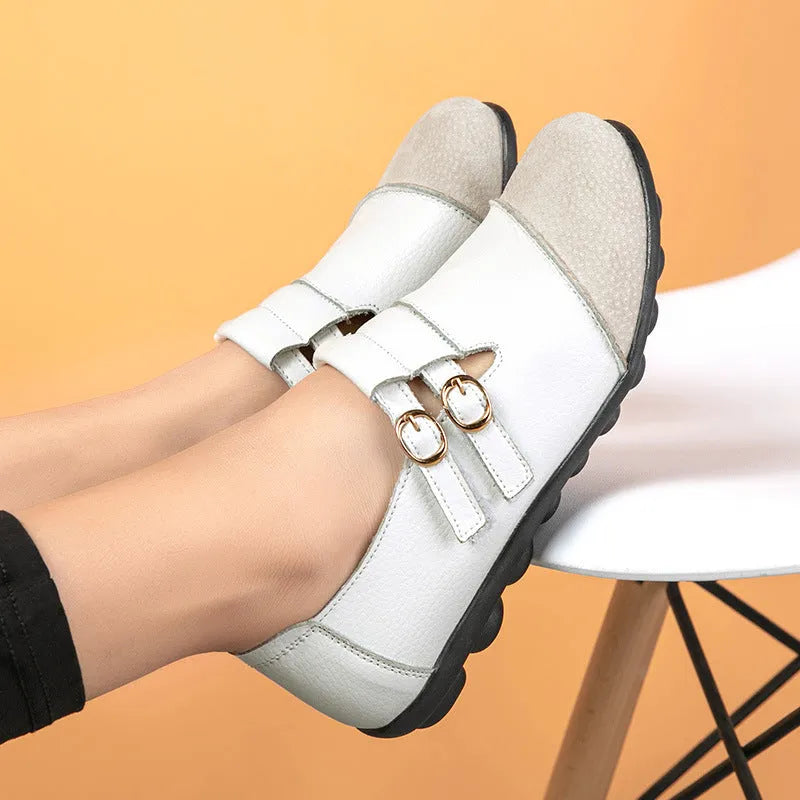 A pair of casual black flat shoes with a round toe, Velcro strap, and cow split leather upper.