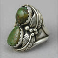 Close-up of a women's turquoise geometric ring with retro inlaid design on a hand.