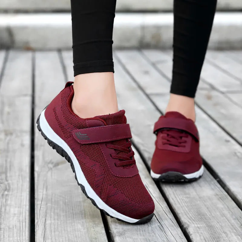 Women's low-top sneakers with Velcro straps and a wedge heel, in a mesh upper and solid colour.