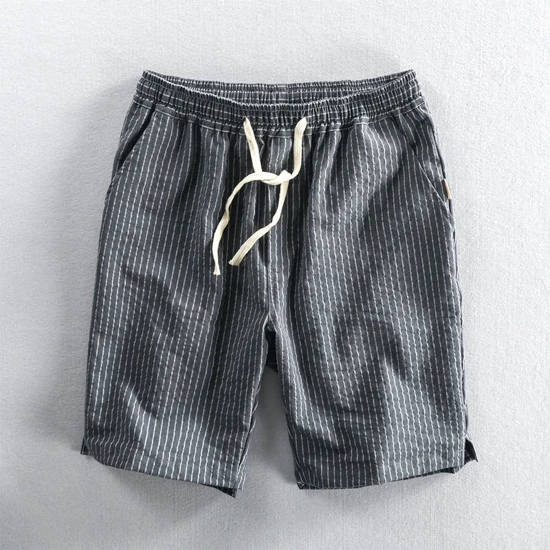 Man wearing black and white striped cotton casual shorts with a loose straight leg and elasticated waist.