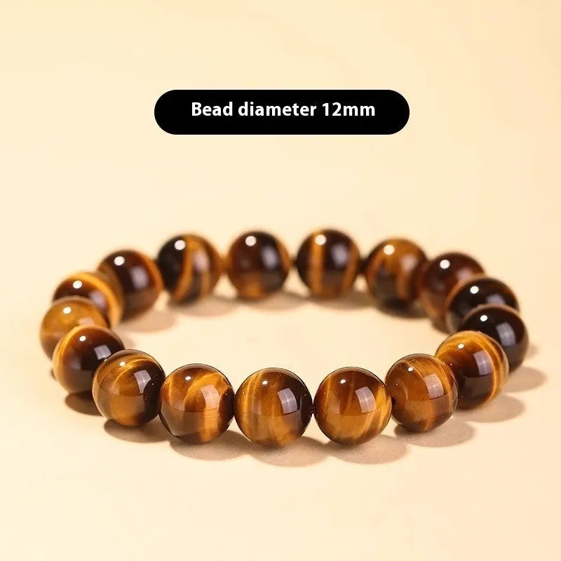 Single circle tigereye stone Buddhist prayer beads bracelet on wrist, showing ethnic design.