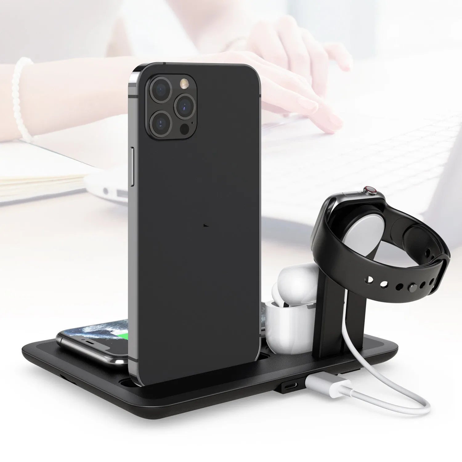 Black and white desktop charging station for wireless phone, watch, and headphone charging with USB cable.