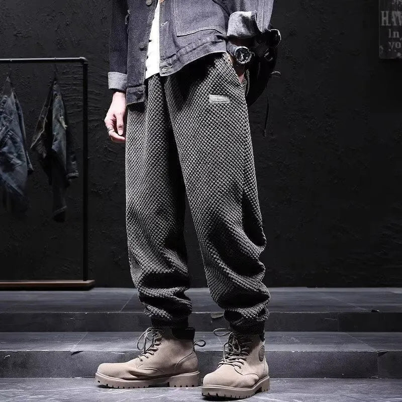 Men's grey straight-leg sweatpants with ankle ties on a plain background.