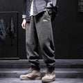 Men's grey straight-leg sweatpants with ankle ties on a plain background.