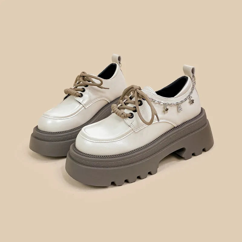 White platform Mary Jane shoes with chunky heel and metal decorations on display