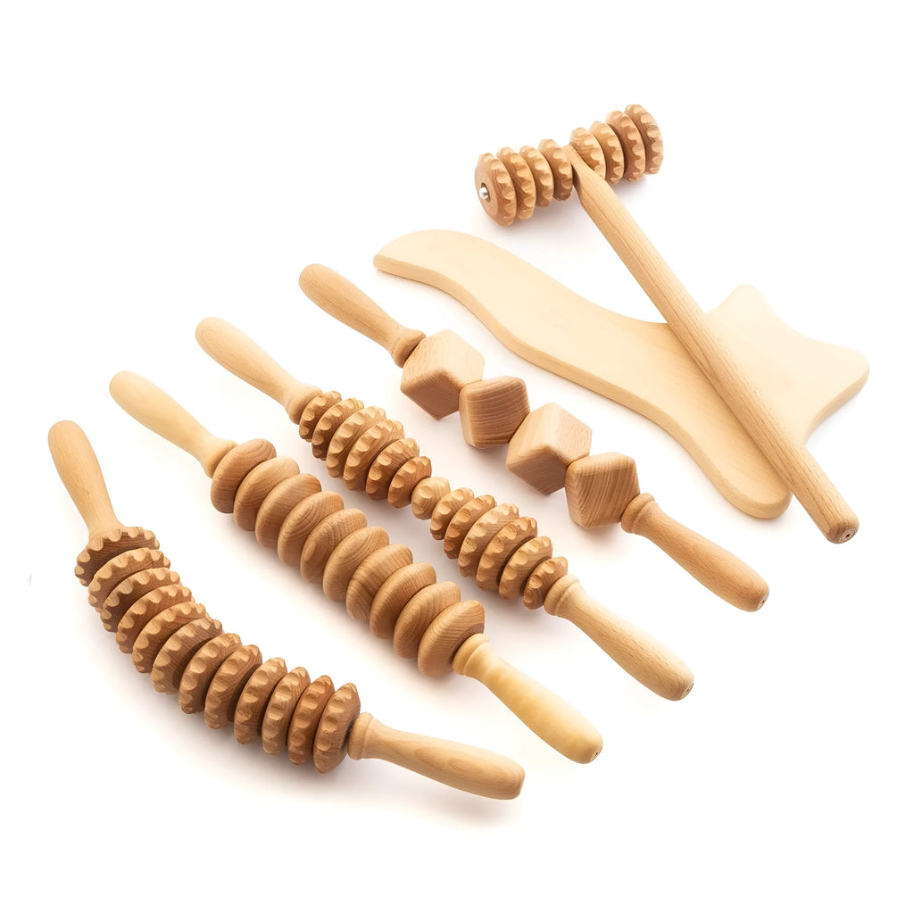 Assorted beech wood massage rollers including T-shaped and multi-wheel sets on a plain surface.