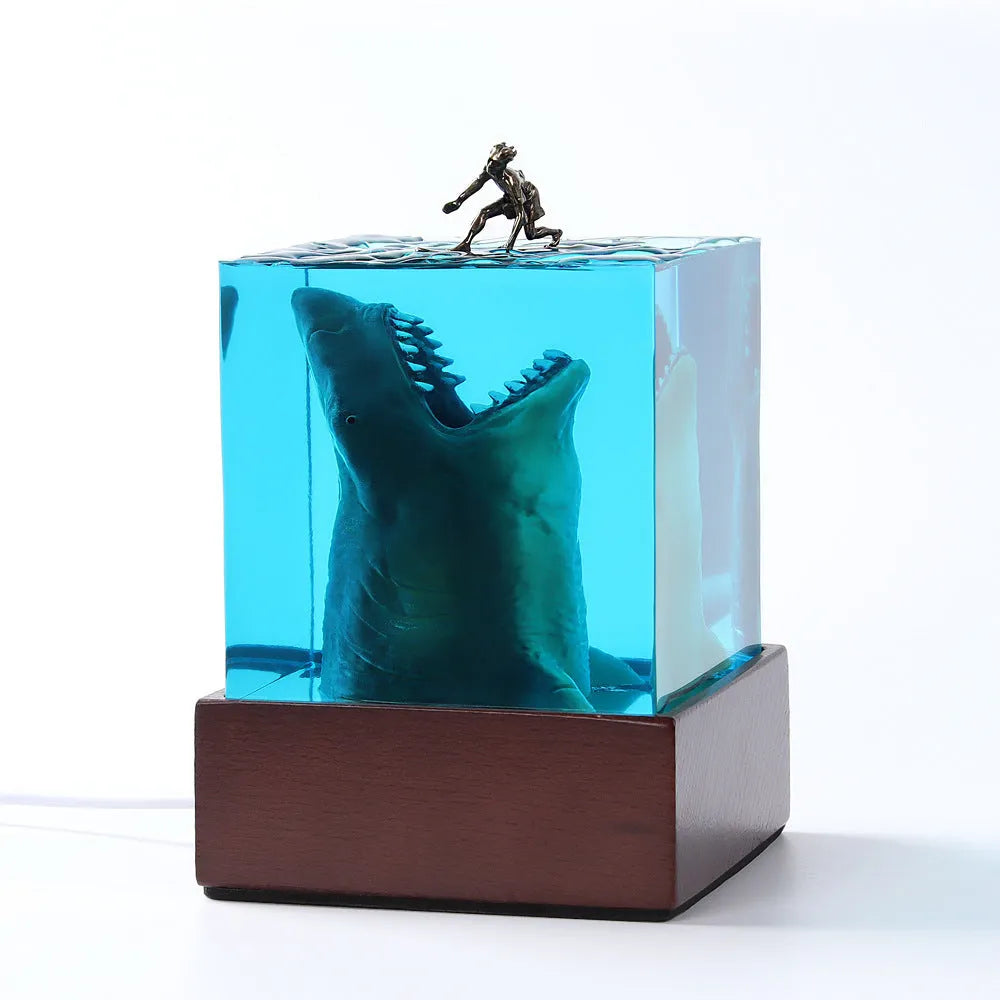 Epoxy resin shark surfer night light ornament with crystal glue details on blue background