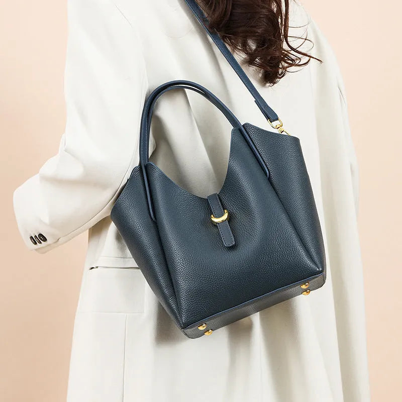 Genuine leather women's retro bucket handbag in beige with top handles and visible stitching.
