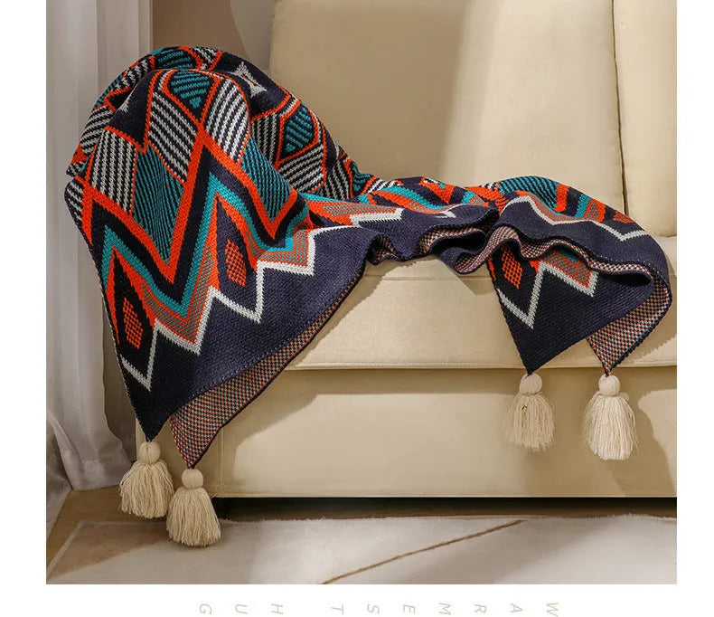 Acrylic sofa blanket with tassels in geometric pattern colour option on a sofa