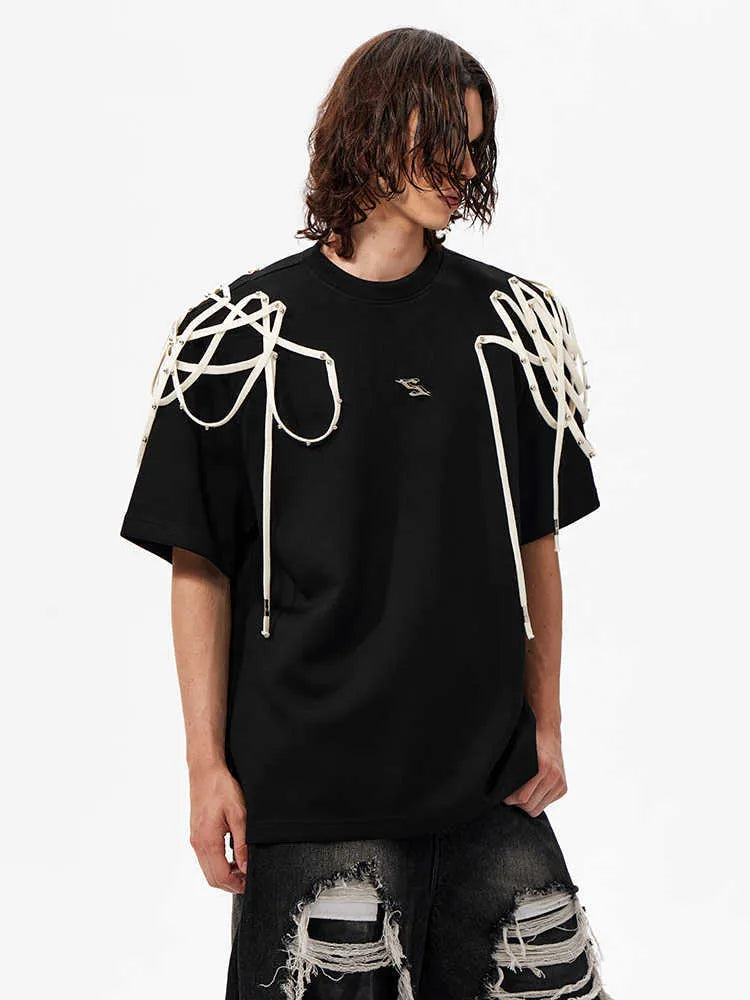 Black loose-fit T-shirt with padded shoulders featuring rivet ribbon detail, short sleeves, and round neck