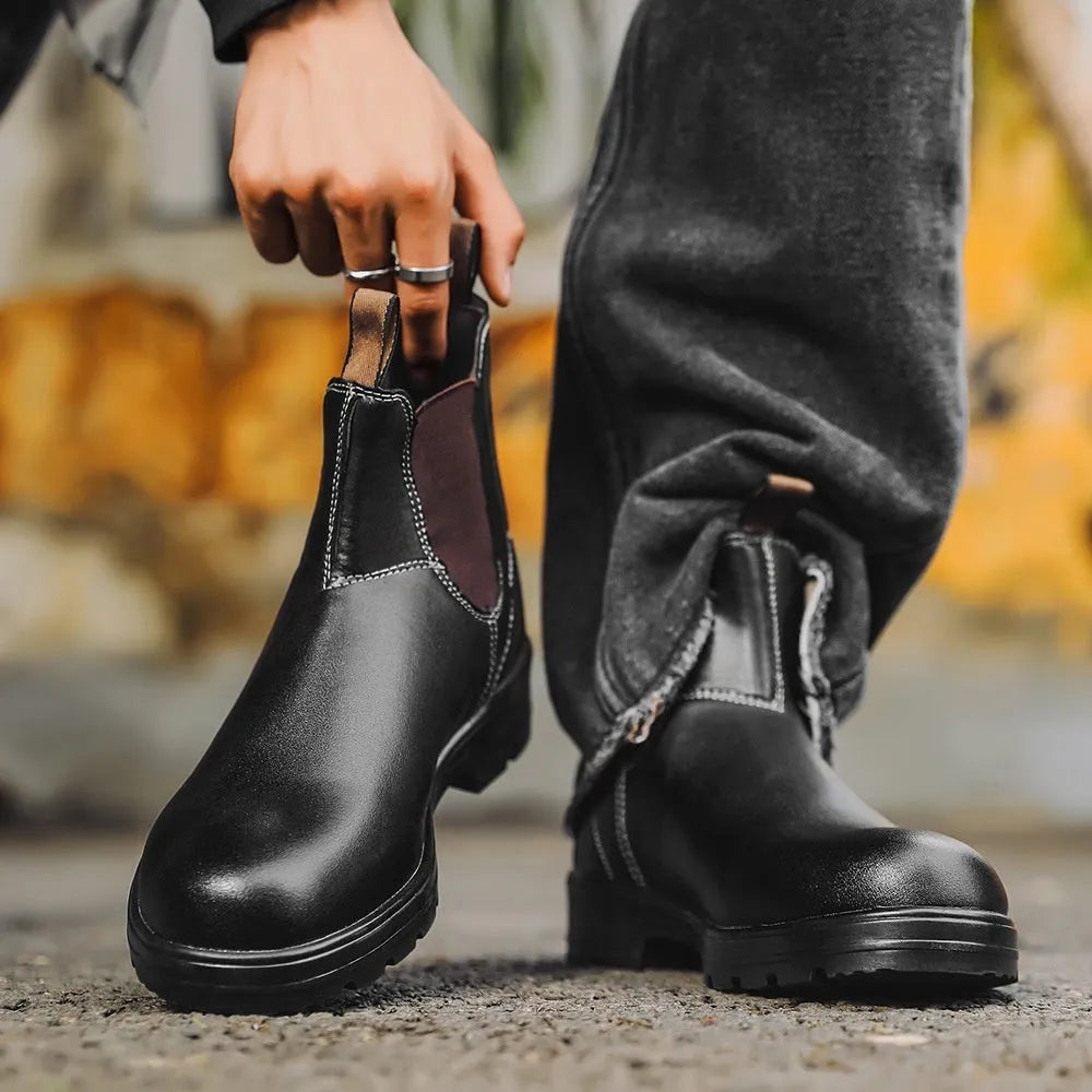 Vintage brown unisex Chelsea boots with a frosted finish, round toe, and low horseshoe heel on a wooden floor.