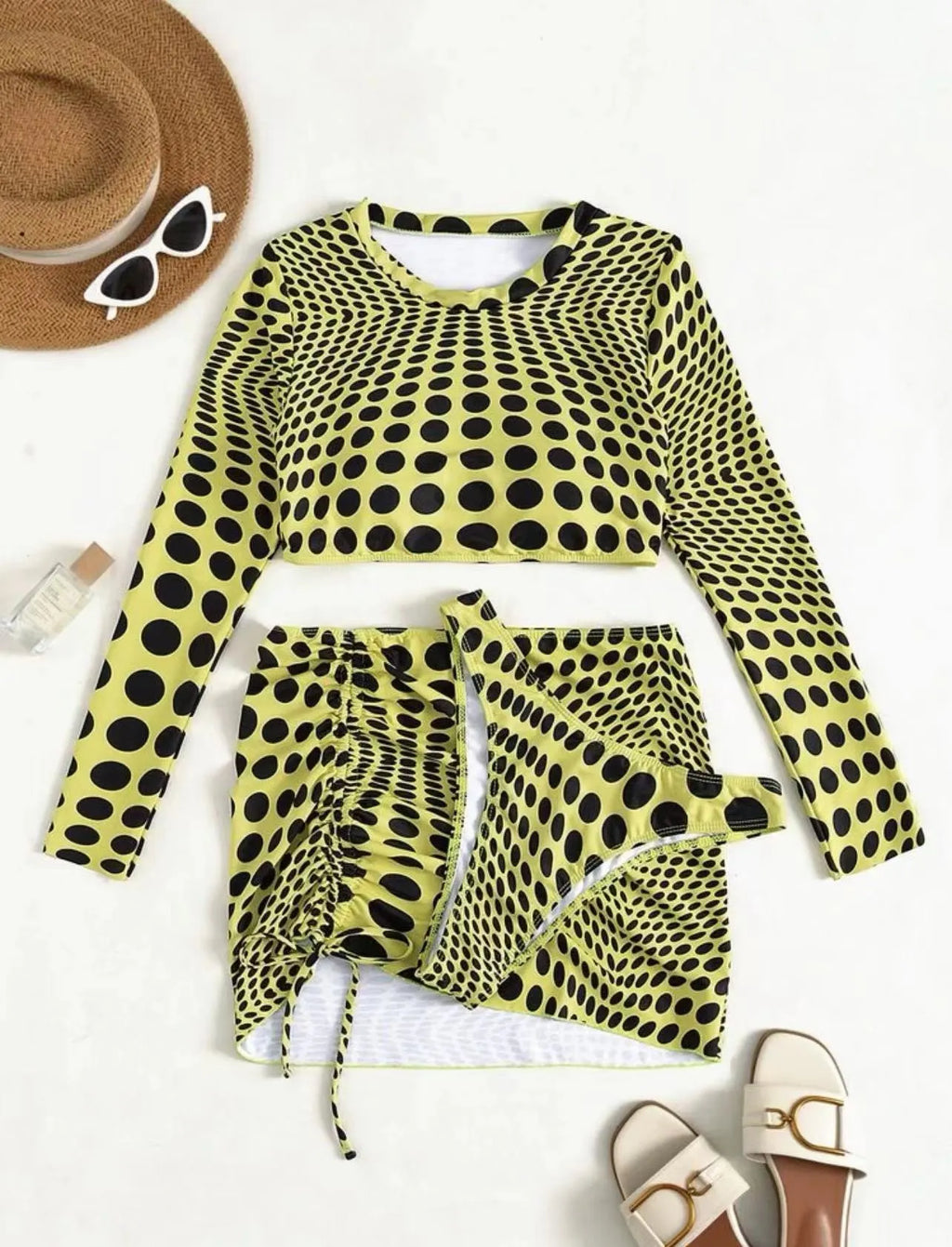 Women's green polka dot three-piece swimsuit set showing bra top and matching skirt
