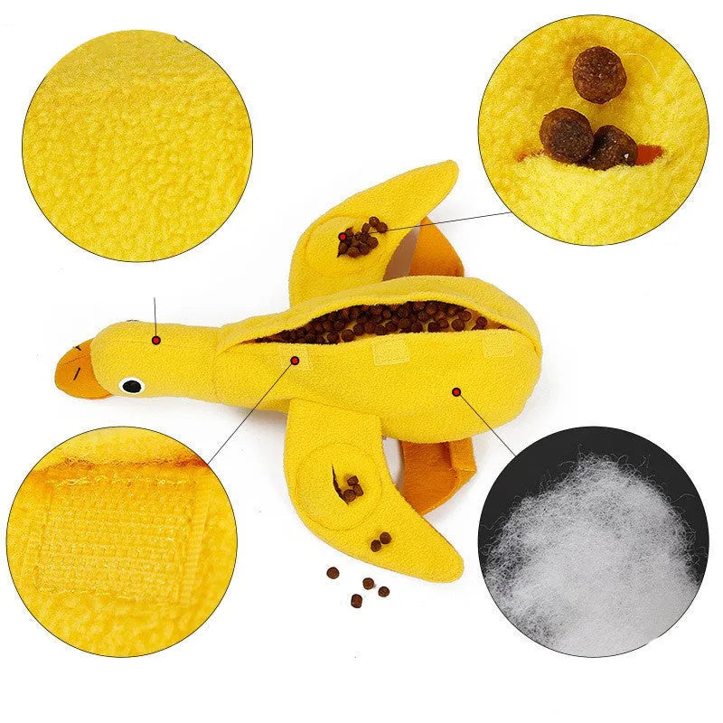 Yellow plush teddy bear dog toy with a small duck doll attached, showing food dispensing holes.