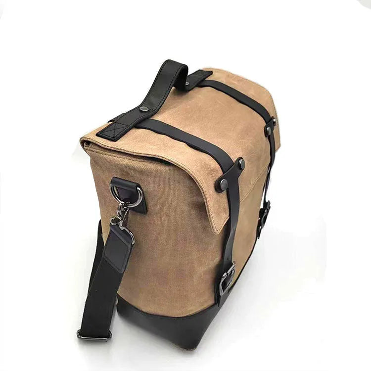 Waterproof canvas motorcycle side pannier bag in black mounted to motorcycle