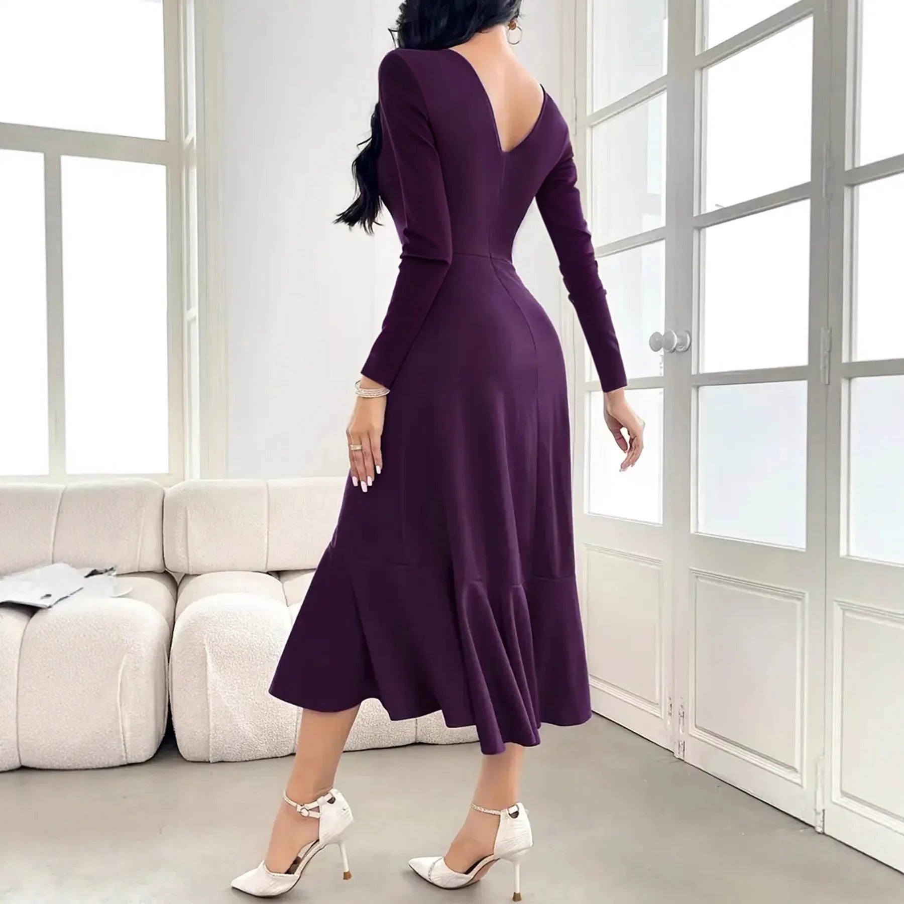 Purple women's long sleeve dress with ruffles, a round neck, and a mid waist fit on a hanger.