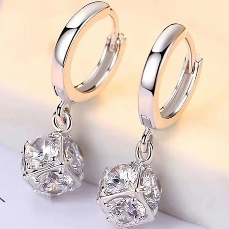 A pair of women's geometric copper earrings with a rose design and small zircon stone accents.