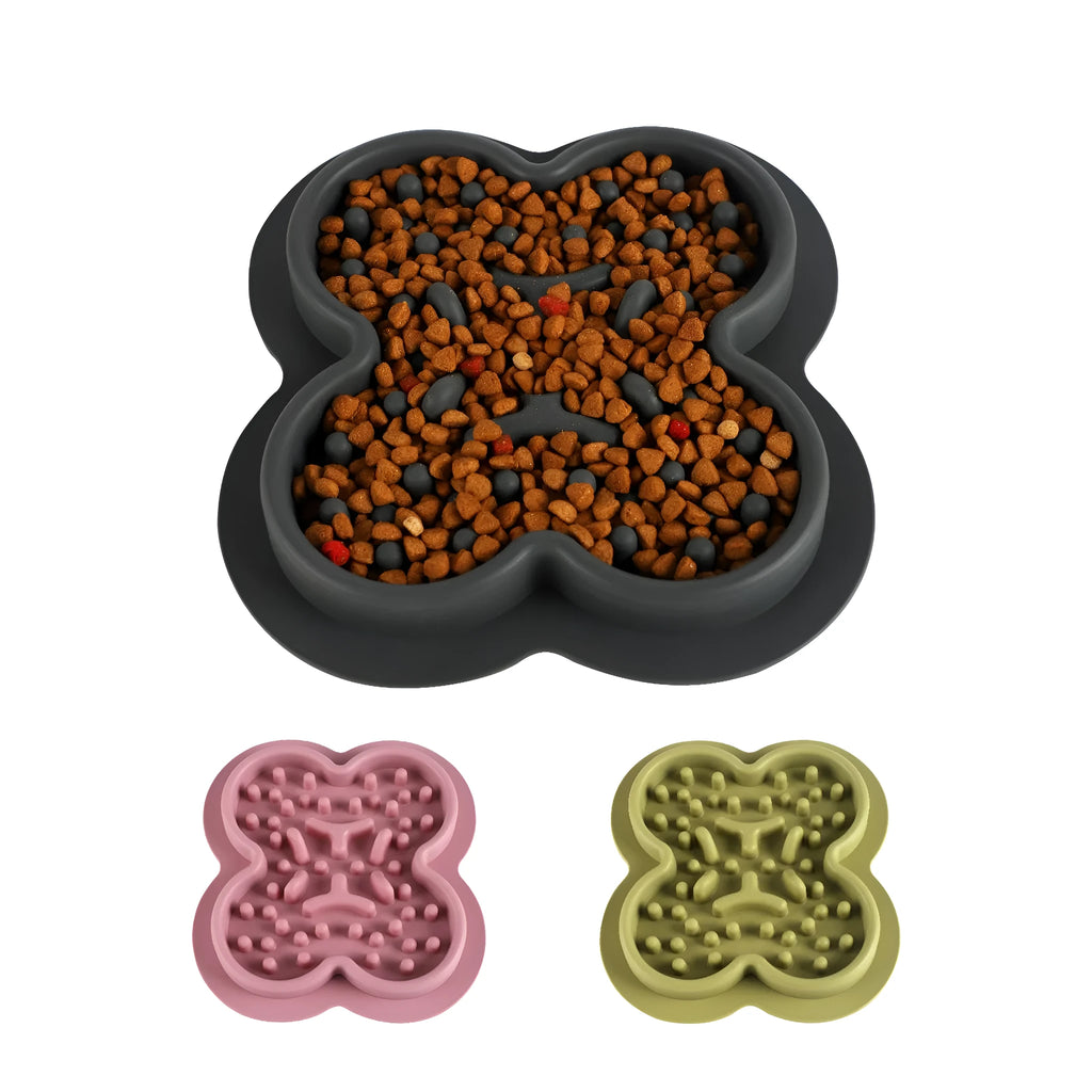Silicone pet slow feeder licking mat with raised edges in assorted colours on a kitchen floor.