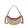 Hard structured straw dumpling shaped women's crossbody shoulder bag in black with contrast stitching.