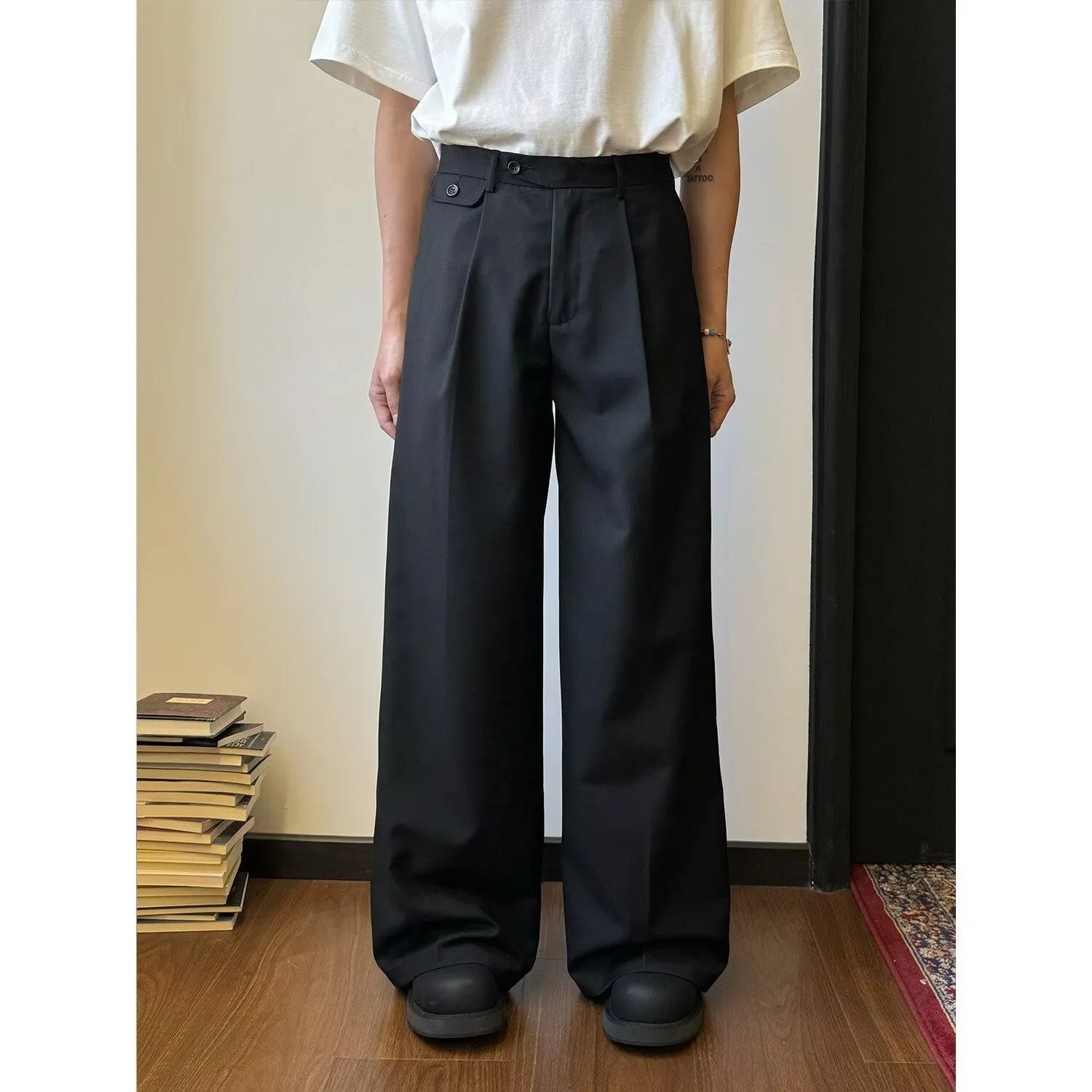 Men's straight-leg loose-fit trousers in brown and black colours on a hanger.