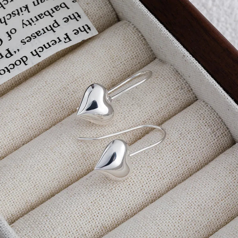 Silver colour heart-shaped earrings with glossy finish and three-dimensional Korean style design