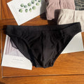 Men's solid colour cotton triangle briefs in mid-waist style, shown in apricot and black colour options.