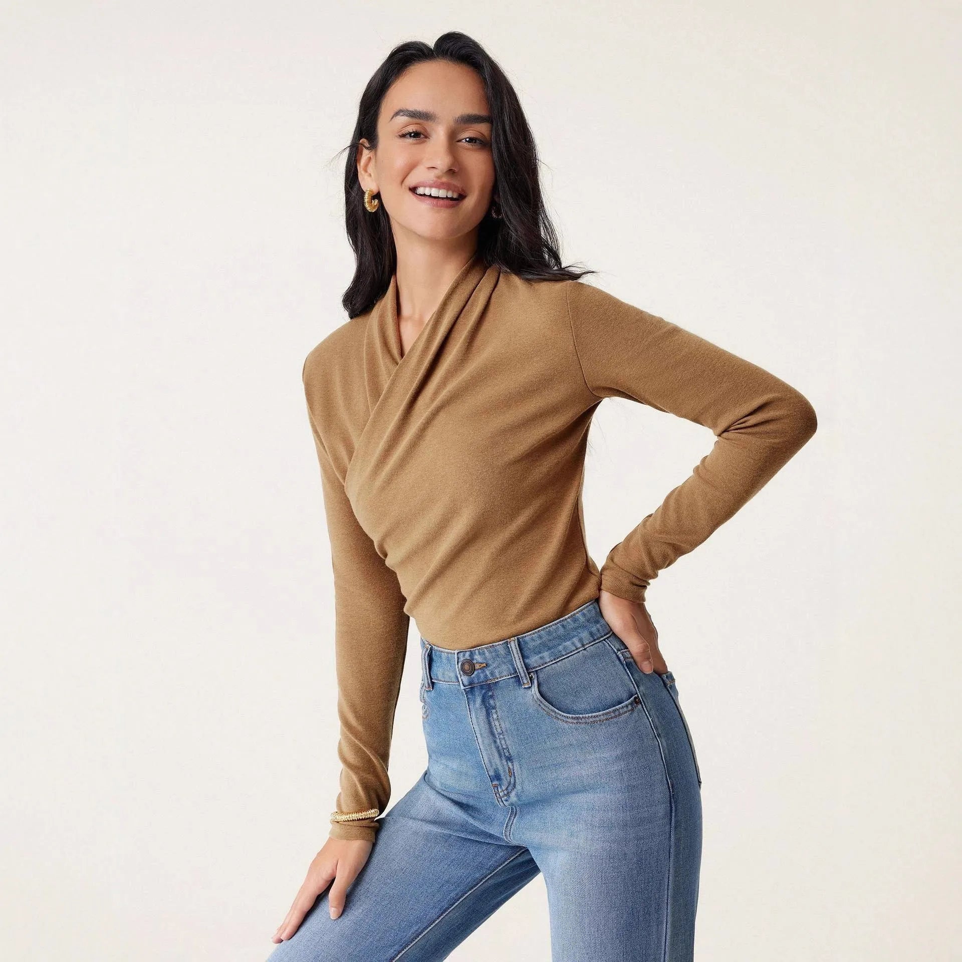 Camel coloured women's slim fit long sleeve pullover sweater on a hanger.