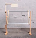 Vertical adjustable pine wood cross stitch embroidery frame on a desktop.