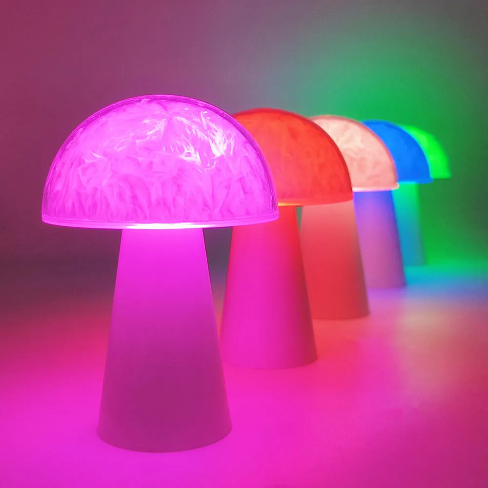 Small white mushroom-shaped decorative night light with RGB colours, remote control, on a wooden table.