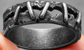 Stainless steel double ring with dark punk stitching detail, showing the layered band design.