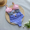 Women's brown one-piece swimsuit with matching beige skirt laid flat