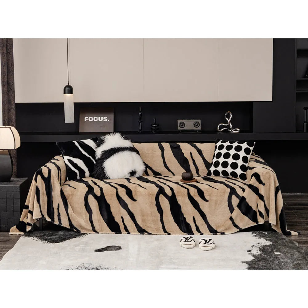 Zebra pattern flannel sofa slipcover in caramel colour, shown draped over a sofa with matching square pillow.