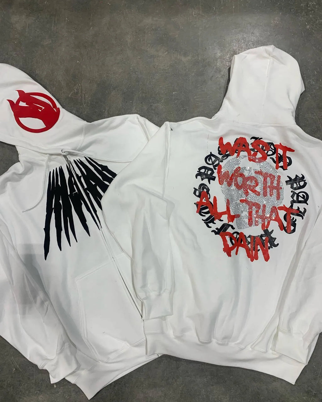Black loose hooded sweatshirt with printed skull and rhinestone lettering on front